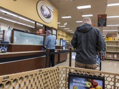 Kirkland, WA USA - Ekim 2021: Safeway 'deki bir marketten reçeteli ilaç alan orta yaşlı bir adamın görüntüsü