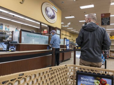 Kirkland, WA USA - Ekim 2021: Safeway 'deki bir marketten reçeteli ilaç alan orta yaşlı bir adamın görüntüsü