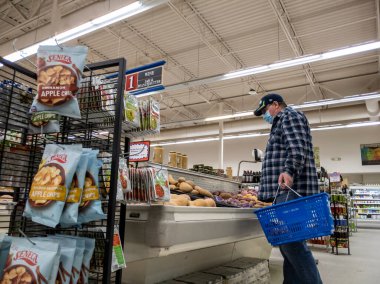 Gold Bar, WA USA - Ocak 2022: Gold Bar Family Grocer 'da yüz maskesi takmış yaşlı bir adamın patates alışverişi yaparken düşük açılı görüntüsü.