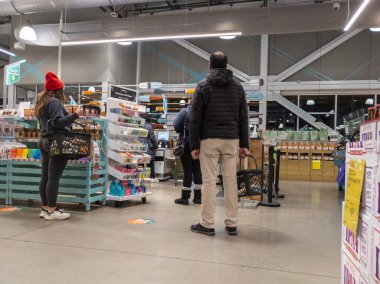 Kirkland, WA USA - Nisan 2022: Whole Foods 'daki bir markette kendi kendini kontrol eden kadın ve erkeklerin kuyruğa girmesi