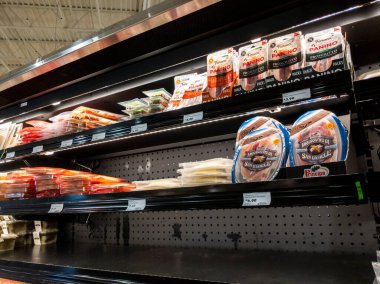 Lynnwood, WA USA - Nisan 2022: Bir kasaba ve taşra bakkal dükkanının şarküterisinde düşük envanter peyniri ve et sergisi manzarası.
