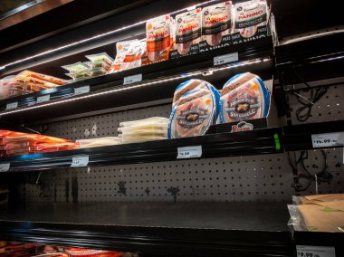 Lynnwood, WA USA - Nisan 2022: Bir kasaba ve taşra bakkal dükkanının şarküterisinde düşük envanter peyniri ve et sergisi manzarası.