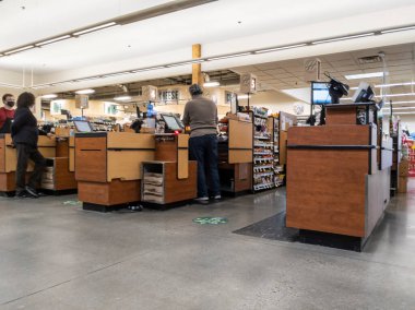 Woodinville, WA USA - Nisan 2022: Haggen Kuzeybatı Taze Marketi 'nde müşterileri bekleyen kasiyerlerin kasadaki açılı görüntüsü.