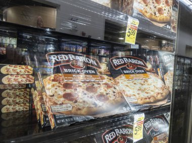 Woodinville, WA USA - Nisan 2022: Haggen marketinin dondurucu koridorundaki Kızıl Baron marka dondurulmuş pizzaların açılı görüntüsü.
