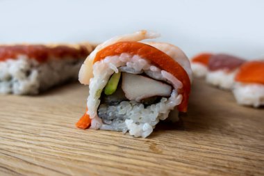 Bambu kesme tahtasındaki çeşitli suşi rulolarının açılı, seçici odak görünümü