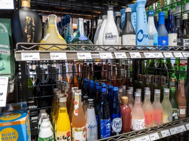 Mill Creek, WA USA - Nisan 2022: Bir kasaba ve ülke bakkalının likör bölümünde satılık çeşitli sake çeşitlerine odaklı