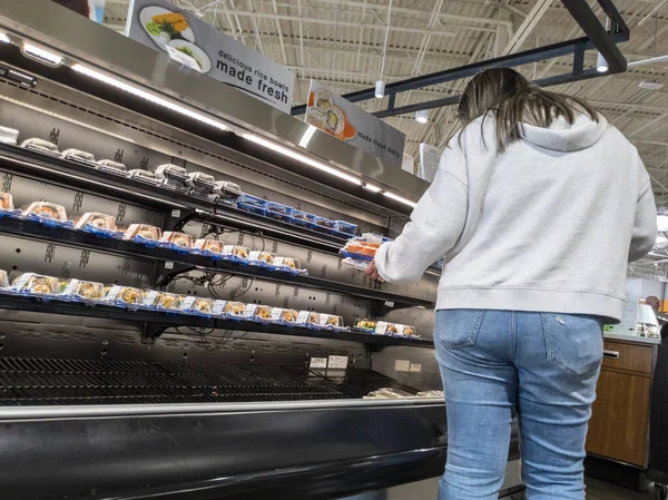 Mill Creek, WA USA - Mayıs 2022: Kasaba ve taşra bakkalından suşi seçen bir kadının görüntüsü.