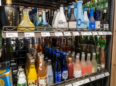 Mill Creek, WA USA - Nisan 2022: Bir kasaba ve ülke bakkalının likör bölümünde satılık çeşitli sake çeşitlerine odaklı