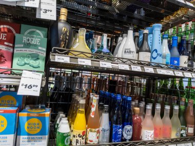 Mill Creek, WA USA - Nisan 2022: Bir kasaba ve ülke bakkalının likör bölümünde satılık çeşitli sake çeşitlerine odaklı.