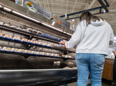 Mill Creek, WA USA - circa May 2022: View of a woman picking out sushi inside a Town and Country grocery store.