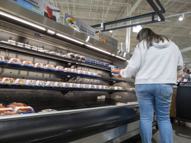 Mill Creek, WA USA - Mayıs 2022: Kasaba ve taşra bakkalından suşi seçen bir kadının görüntüsü.