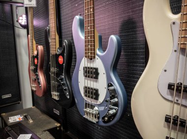 Lynnwood, WA USA - Mayıs 2022: Gitar Merkezi müzik enstrümanları mağazasında satılmak üzere elektirik ve akustik bas gitarlara seçici odaklanma.