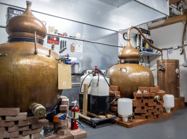 Woodinville, WA USA - Ağustos 2021: Cinin büyük bakır kaplarda damıtıldığı Pacific Distillery 'nin iç manzarası.