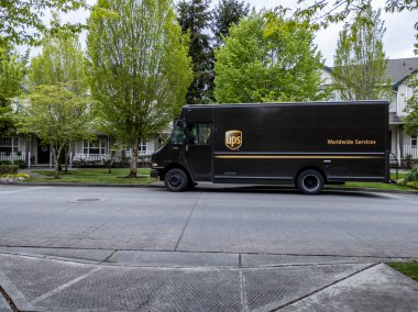 Mill Creek, WA USA - circa May 2022: Front view of a UPS brown delivery truck outside of a residential home, making a delivery.
