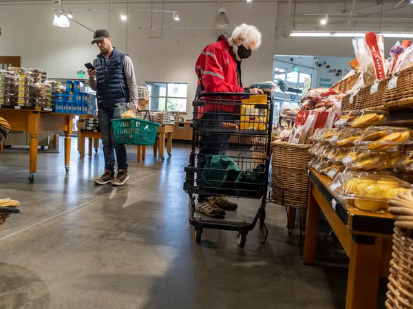 Mill Creek, WA USA - circa May 2022: View of an elderly man shopping in the breads and pastries section of a Town and Country grocery store