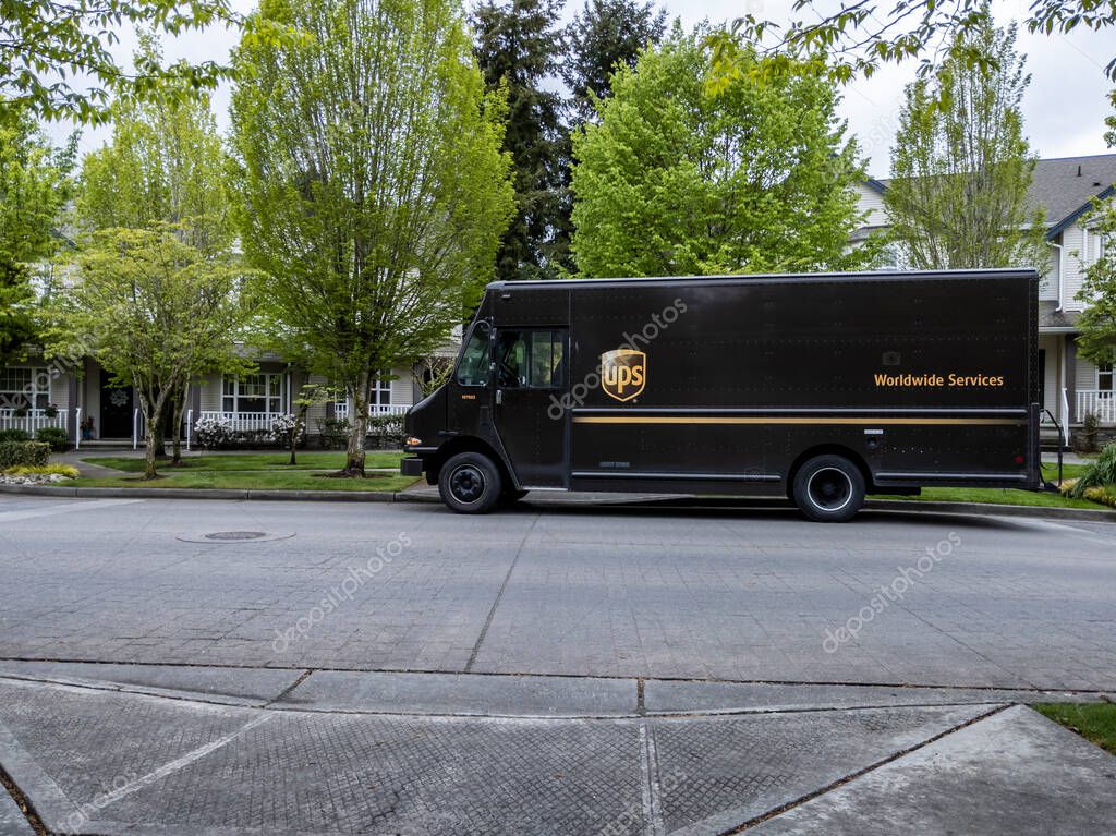 Mill Creek, WA USA - circa May 2022: Front view of a UPS brown delivery truck outside of a residential home, making a delivery.