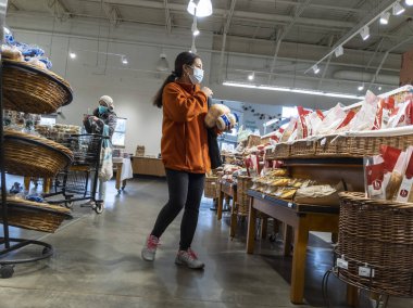 Mill Creek, WA USA - Nisan 2022: Bir kasaba ve kasaba bakkalının pastanesinde alışveriş yapan bir kadının görüntüsü