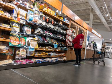 Mill Creek, WA USA - Nisan 2022: Bir kasaba ve kasaba bakkalının pastanesinde alışveriş yapan bir kadının görüntüsü