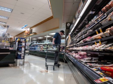 Mill Creek, WA USA - Mayıs 2022: QFC bakkalının et reyonunda et alışverişi yapan bir adamın yan görüntüsü.