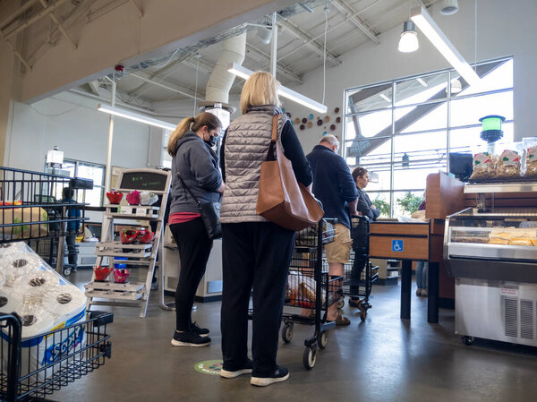 Mill Creek, WA USA - circa May 2022: View of people waiting in line to checkout at a cash register inside a Town and Country grocery store.