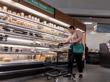 Mill Creek, WA USA - circa May 2022: View of a woman shopping in the deli and easy meals section of a Town and Country grocery store.