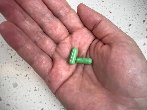 Vue Rapprochée Deux Pilules Vertes Dans Paume Une Main Adulte — Photo