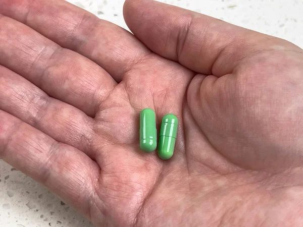 Vue Rapprochée Deux Pilules Vertes Dans Paume Une Main Adulte — Photo