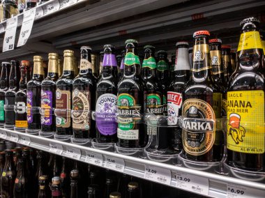 Mill Creek, WA USA - Mayıs 2022: Bir kasaba ve taşra bakkalında satılık uzun cam bira şişeleri seçici bir odak noktası