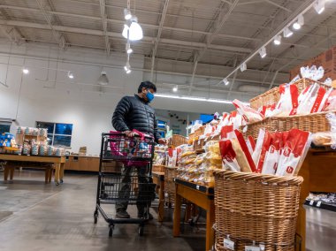 Mill Creek, WA USA - circa May 2022: View of an Indian man shopping for bread inside the bakery of a Town and Country Market.
