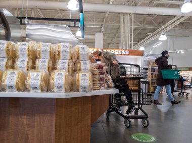Lynnwood, WA USA - Mart 2022: Bir kasaba ve ülke marketinde orta yaşlı bir kadının pasta ve kek alışverişi yapması