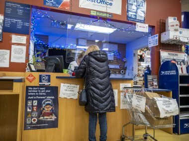 Kirkland, WA USA - Aralık 2021: Bayram sezonu boyunca USPS 'de paket taşıyan bir kişinin açılı görüşü