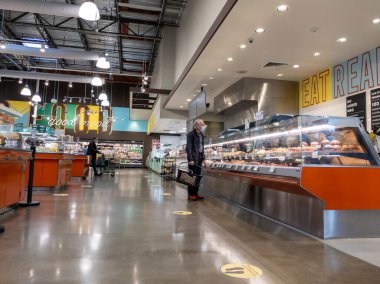 Kirkland, WA USA - Eylül 2021: Whole Foods Market 'in içindeki açık büfede maske takan yaşlı bir adamın görüntüsü.