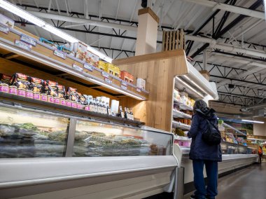 Kirkland, WA USA - Eylül 2021: Bir Tüccar Joe 'nun marketinde dondurucu koridorunda alışveriş yapan bir kadının görüntüsü