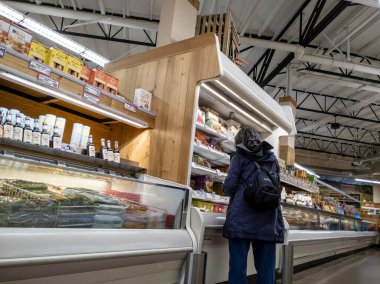 Kirkland, WA USA - Eylül 2021: Bir Tüccar Joe 'nun marketinde dondurucu koridorunda alışveriş yapan bir kadının görüntüsü.