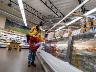 Kirkland, WA USA - Eylül 2021: Bir Tüccar Joe 'nun marketinde dondurucu koridorunda alışveriş yapan bir kadının görüntüsü.