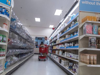 Lynnwood, WA USA - Mart 2022: Kızıyla birlikte bir marketin sağlık ve güzellik departmanından alışveriş yapan bir adamın görüntüsü.