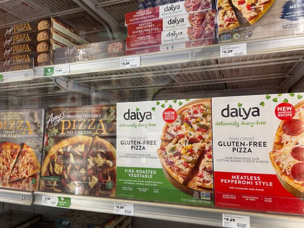 Mill Creek, WA USA - Mayıs 2022: Bir kasaba ve ülke pazarının dondurucu bölümünde satılık çeşitli dondurulmuş pizzaların açılı görünümü.