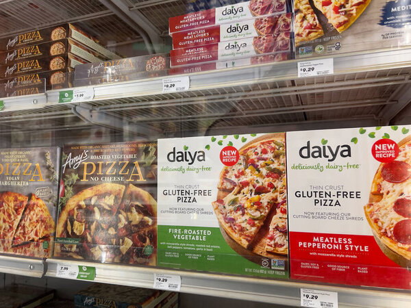 Mill Creek, WA USA - circa May 2022: Angled view of a variety of frozen pizzas for sale inside the freezer section of a Town and Country Market.