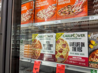 Mill Creek, WA USA - Mayıs 2022: Bir kasaba ve ülke pazarının dondurucu bölümünde satılık çeşitli dondurulmuş pizzaların açılı görünümü.