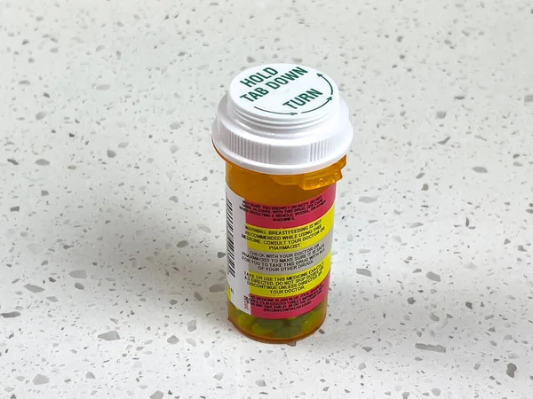 Angled view of the warning labels on the side of a prescription pill bottle
