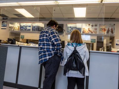 Mill Creek, WA USA - circa May 2022: Angled view of people mailing packages inside a post office.