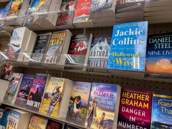 Seattle, WA USA - circa May 2022: Angled close up view of romance and crime books for sale inside a QFC grocery store.