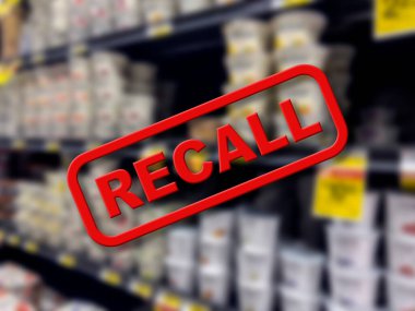 Blurry interior of a grocery store aisle behind large red Recall text