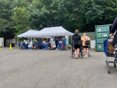 Mill Creek, WA USA - circa August 2022: Wide view of people shopping for groceries at a food pantry at a local church