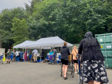 Mill Creek, WA USA - circa August 2022: Wide view of people shopping for groceries at a food pantry at a local church