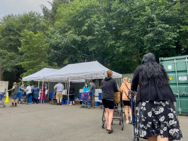 Mill Creek, WA USA - circa August 2022: Wide view of people shopping for groceries at a food pantry at a local church