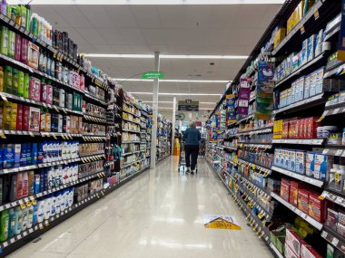 Seattle, WA USA - Eylül 2022: Bir QFC marketinde hijyen koridorunda alışveriş yapan bir kadının geniş görünümü.