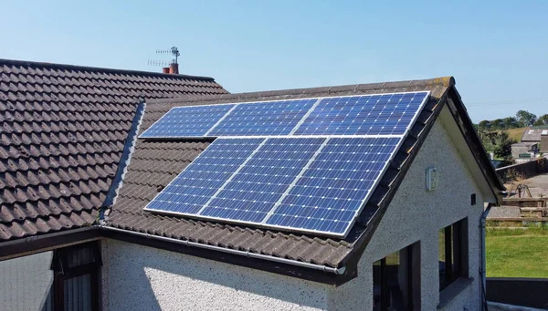 Solar panels on a roof of a home generating renewable electric energy