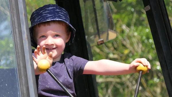 小男孩在农场里玩一个老的黄色挖掘机 — 图库照片