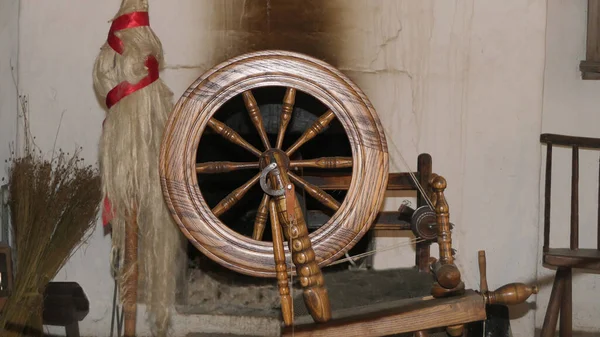 A spinning wheel used to spin sheeps wool in an old Irish cottage